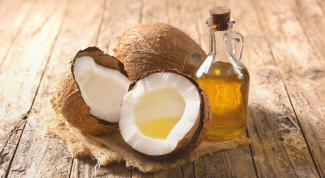 Image of coconut and coconut oil on wooden surface